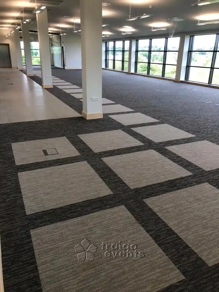 A black coloured carpet with grey squares fitted for an event hall