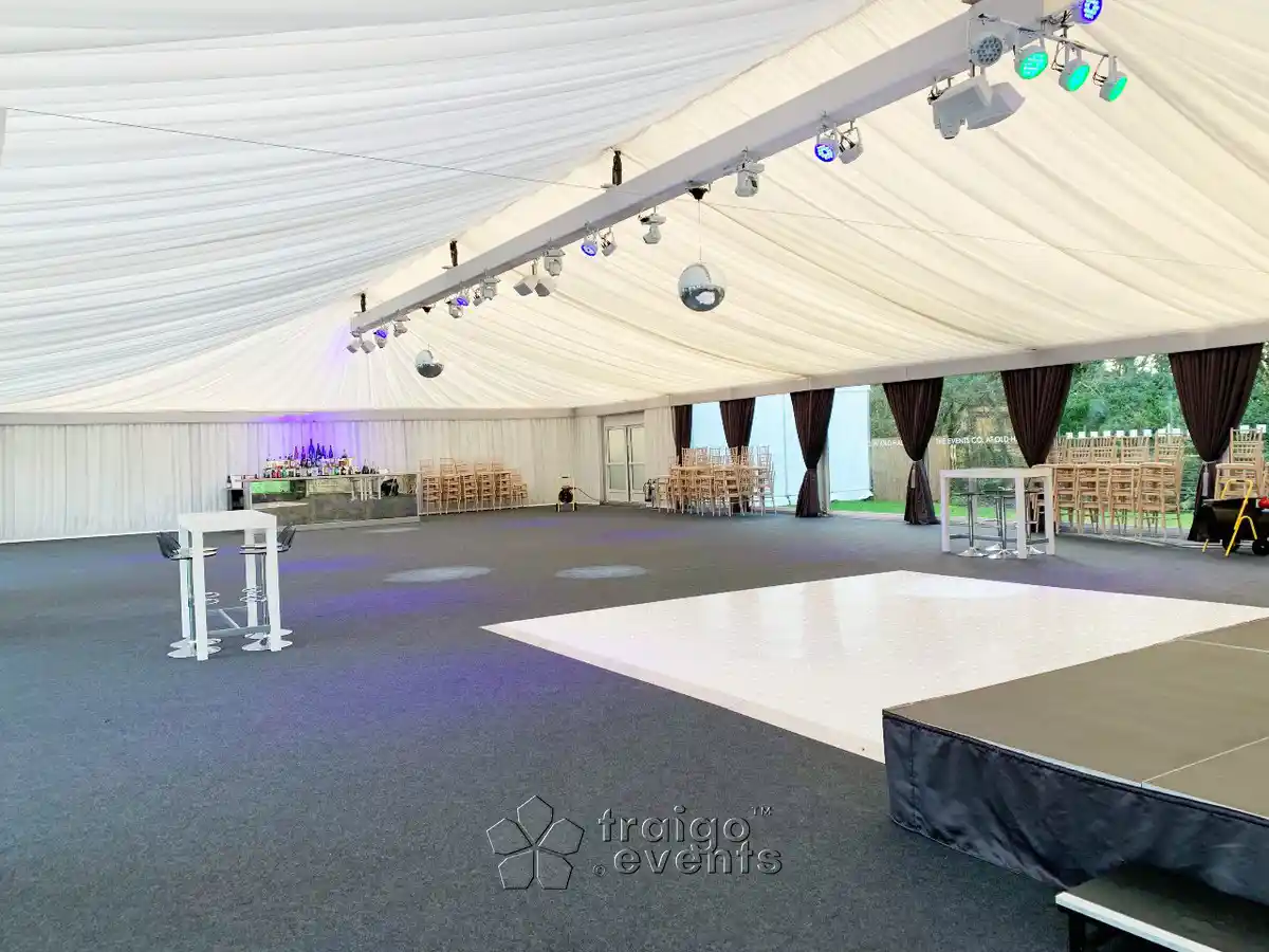 Tent set-up for an event installed with grey coloured carpeting